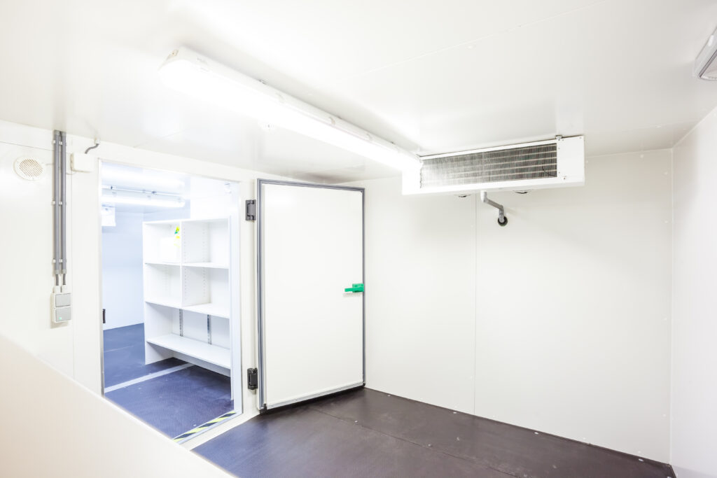 an empty industrial room refrigerator with four fans