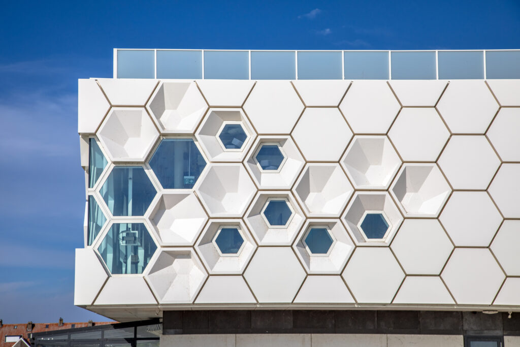 Closeup of modern facade of geometric architecture building in the Netherlands against blue sky.